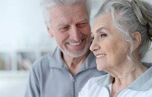 senior couple smiling with their dentures